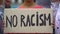 Mixed-race girl holds sign No racism, suffers crowd screaming racial insults