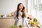 Mixed race girl younger and older sister talk and smile while play and using smartphone inside of the kitchen in the morning while