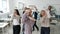 Mixed race group of businesspeople having fun in office dancing together enjoying teamwork