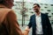 mixed race male business officer shaking hands with female colleague walking to work office