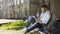 Mixed-race male sitting under tree, writing in sketchbook, innovative idea