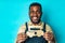 mixed race man holding paper car with recharging socket in blue studio background eco electro car concept