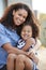 Mixed race mother and young daughter smile to camera outside