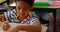 Mixed-race schoolboy studying at desk in classroom at school 4k