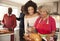 Mixed race senior and young adult family members talking in the kitchen while preparing Christmas dinner together, close up