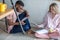 Mixed-race students sitting together on kitchen floor at home prepare to exams