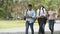 Mixed-race students and teacher walking in park and talking, higher education