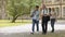 Mixed-race students and teacher walking in park and talking, higher education