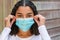 Mixed Race Teenager Girl Woman Wearing Adjusting Coronavirus COVID-19 Face Mask