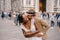 Mixed-race wedding couple. Wedding in Florence, Italy. Caucasian groom hugs from behind and kisses African-American