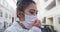 Mixed race woman coughing on her medical coronavirus mask