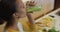 Mixed race woman drinking healthy drink in kitchen