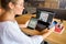 Mixed race woman in glasses working with multiple electronic internet devices. Freelancer businesswoman has tablet and