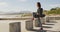 Mixed race woman holding skateboard stopping to enjoy the view by the sea