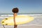 Mixed race woman holding a surfboard  on the beach