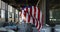 Mixed race woman holding us flag running through an empty building