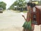 Mixed race Woman Reading Postcard By Mailbox