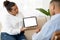 Mixed race woman therapist showing male patient digital tablet, mockup