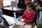 Mixed race woman wearing face mask disinfecting smartphone at her office desk