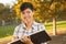 Mixed Race Young Female Holding Sketch Book and Pencil Outdoors