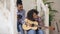 Mixed race young woman sitting on stairs teaching her teenage sister to play acoustic guitar at home