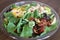 Mixed Salad in a clear round plastic bowl.