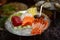 Mixed sliced fish sashimi on ice in black bowl. Sashimi Salmon Tuna Hamachi Prawn and Surf Calm set, raw fish, shrimps japanese fo