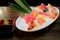 Mixed sliced fish sashimi on ice in white bowl. Sashimi Salmon Tuna Hamachi Prawn and Surf Calm set, raw fish, japanese food in