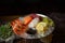 Mixed sliced fish sashimi and shrimps on ice in black bowl. Sashimi Salmon Tuna Hamachi Prawn and Surf Calm set, raw fish, japanes