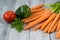 Mixed vegetables. Carrots, paprika, tomato and herbs on wooden background