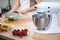 Mixer on the kitchen table with fruits on a white background, cooking cream