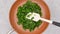 Mixing baby spinach on a frying pan. Close up view from above