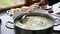 Mixing the cheese mass in a saucepan when making homemade cheese
