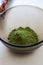 Mixing henna with a wooden spoon in a bowl for hair application of natural color like Indian henna mix