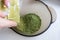 Mixing henna with a wooden spoon in a bowl for hair application of natural color like Indian henna mix