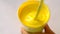 Mixing yellow paint on a white background closeup