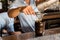 Mixologist making cocktail with Shaker, pouring through the filter in wooden drinking glass with ice cubes on cocktail counter bar