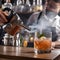A mixologist using a smoking gun to infuse a cocktail with aromatic smokiness1