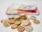 Mixture of Euro coins and banknotes lying on a white desk. Notes and coins of various denominations.