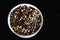 A mixture of pepper varieties with peas on the white plate on the black background. Heap of various pepper. Mix of red