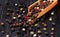 Mixture of peppercorns scattered on the wooden background