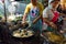 Mn and woman making traditional pad thai and oyster omelette