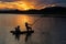 Mo lake with a couple of fishers catching fish by net trap in beautiful sunset period in Son Tay town, Hanoi, Vietnam