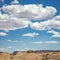 Moab desert landscape under blue sky with clouds