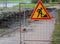 Moat enclosed by a lattice fence with signs of earthworks for laying underground communications