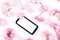 Mobil smart phone surrounded by pink cherry flowers.