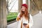 Mobile broadband and people. Smiling redhead 20s girl with backpack, uses smartphone on street, holds mobile phone and