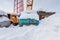 Mobile construction crane with hook and some trucks are in the snowdrift