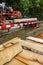 Mobile industrial sawing machine on a truck trailer in operation when sawing logs, in the foreground are sawn boards on a pile