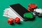 Mobile phone casino online. Mobile phone and game cards with chips and dice on a green gaming table. Gambling addiction